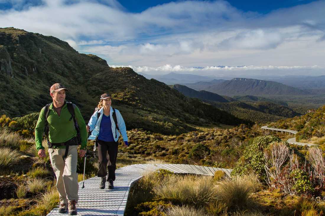 Couple walking Hump Ridge Track - Great South NZ |  Pink Penguin Studio